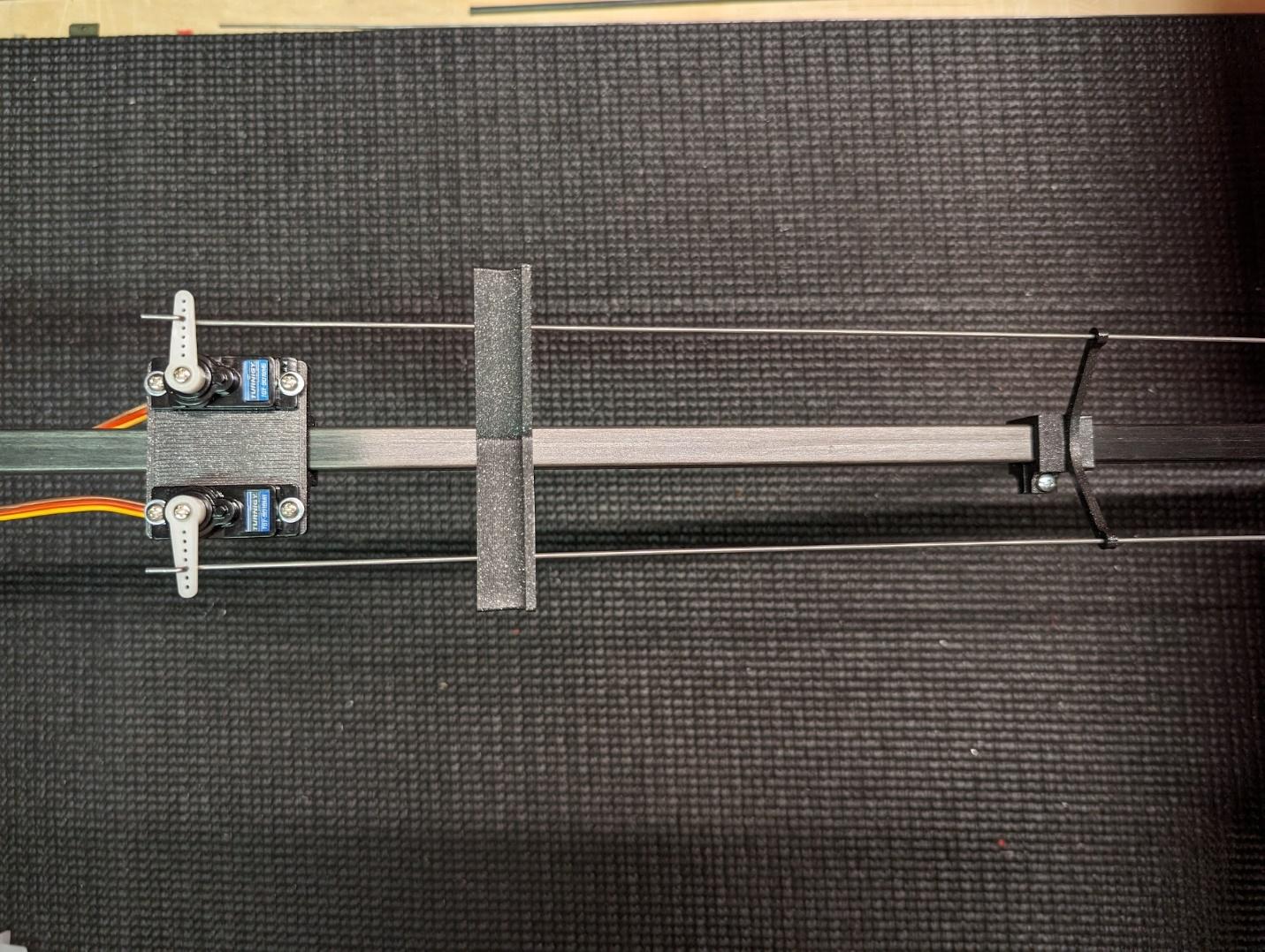 Servos attached and pushrods fed through the guide